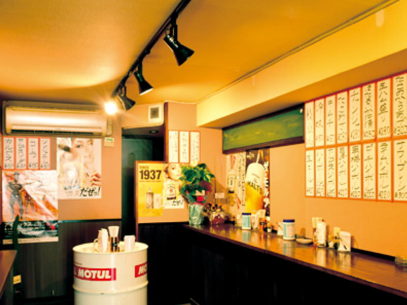 『立ち呑み わっしょい酒場　タチノミ ワッショイサカバ』カウンターとドラム缶のテーブルのみのスタンディングスタイル